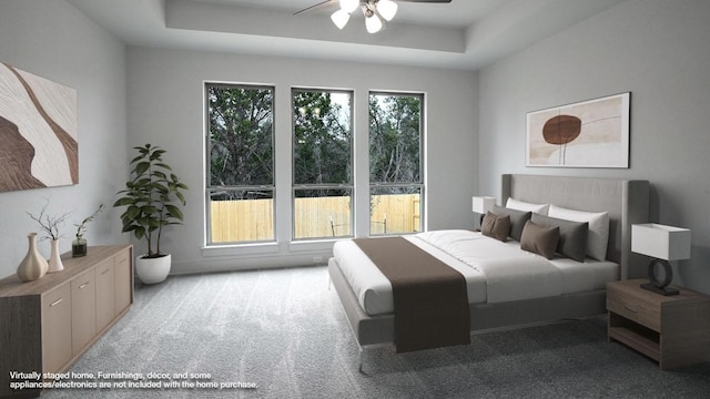 carpeted bedroom with ceiling fan and a raised ceiling