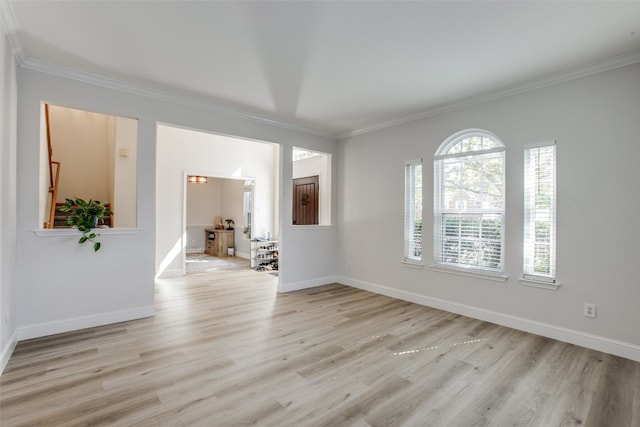 spare room featuring crown molding and light wood-type flooring