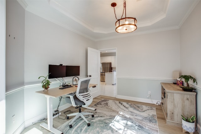 office featuring light hardwood / wood-style flooring, crown molding, and a tray ceiling