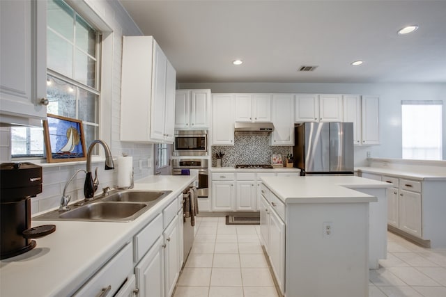 kitchen with a center island, white cabinets, stainless steel appliances, and sink