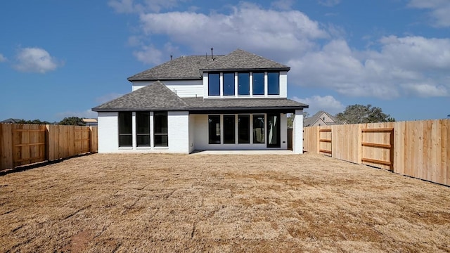 rear view of house with a patio and a yard