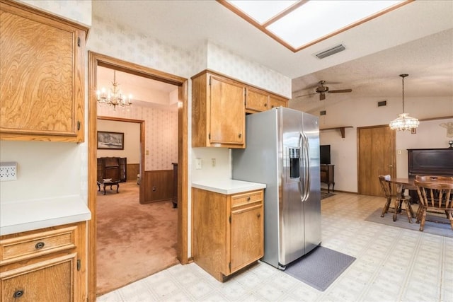 kitchen with visible vents, stainless steel refrigerator with ice dispenser, wallpapered walls, lofted ceiling, and light floors