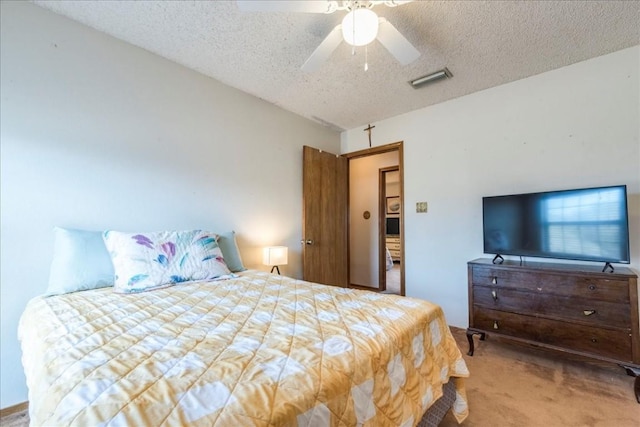 bedroom featuring visible vents, a textured ceiling, a ceiling fan, and carpet floors