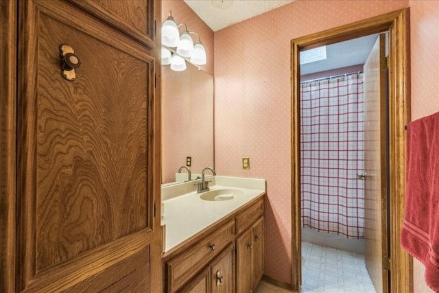 bathroom featuring tile patterned floors, shower / bath combo with shower curtain, a textured ceiling, wallpapered walls, and vanity