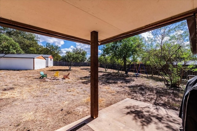 view of yard with an outdoor structure, a fenced backyard, and a patio area