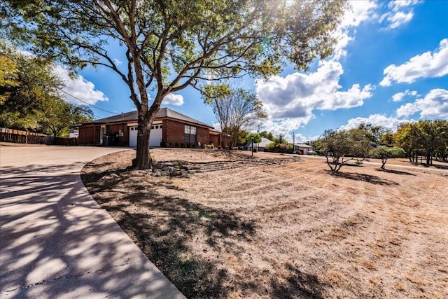 view of yard with a garage and driveway