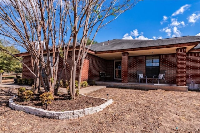 rear view of house with brick siding and a patio area