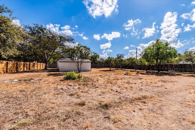 view of yard with an outbuilding, a fenced backyard, and a storage shed