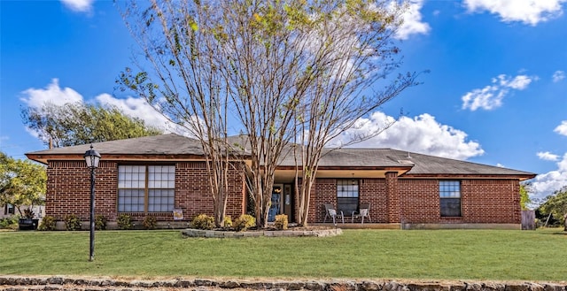 ranch-style house featuring a front yard and brick siding