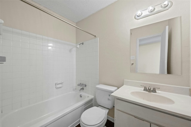 full bathroom featuring toilet, tiled shower / bath, a textured ceiling, and vanity