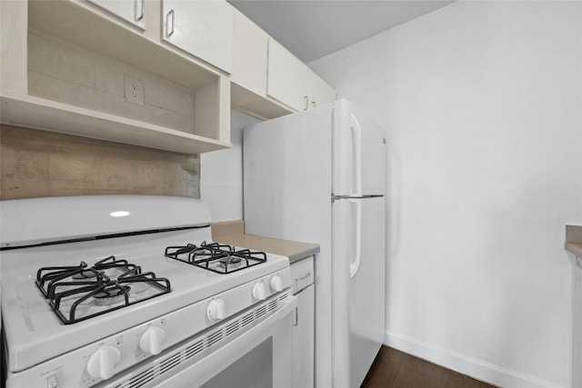 kitchen with dark hardwood / wood-style flooring, white cabinets, and white appliances