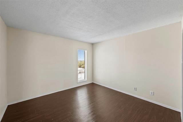 empty room featuring dark wood-type flooring and a textured ceiling