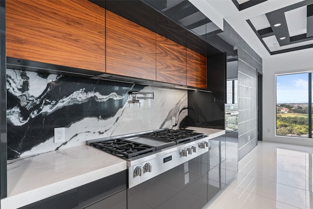 kitchen featuring stainless steel gas stovetop, backsplash, and light tile patterned floors