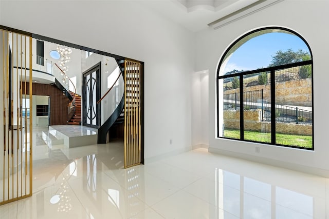 tiled entrance foyer with a notable chandelier and a high ceiling