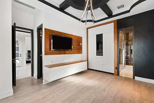 interior space with beamed ceiling, coffered ceiling, a notable chandelier, and light wood-type flooring