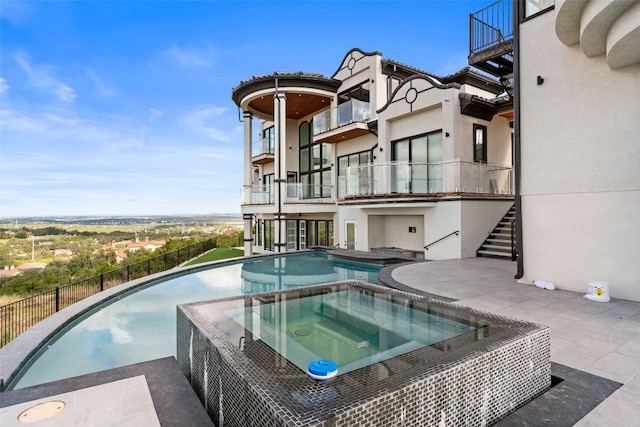 view of swimming pool with an in ground hot tub