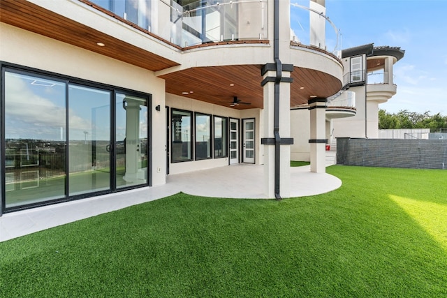 back of house featuring a patio area, a balcony, a yard, and ceiling fan