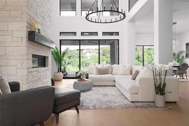 living room with a fireplace, wood-type flooring, and a high ceiling