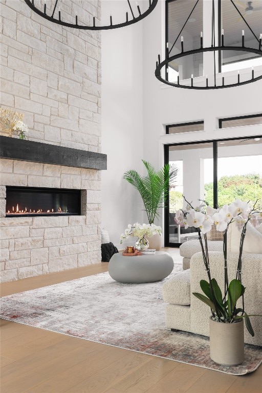 living room featuring a fireplace, hardwood / wood-style floors, and a towering ceiling