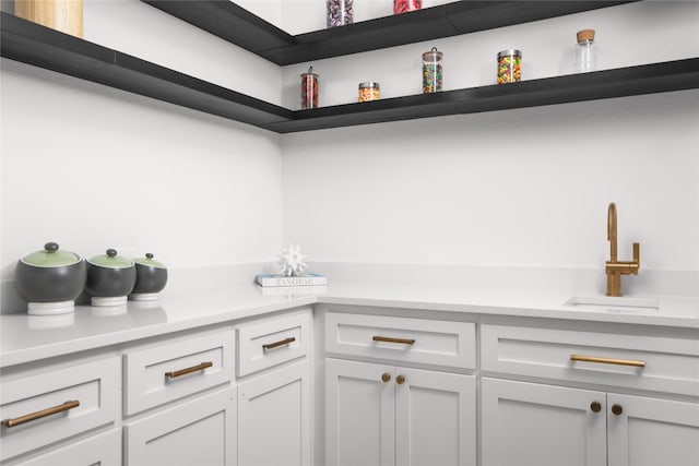 bar with white cabinets and sink