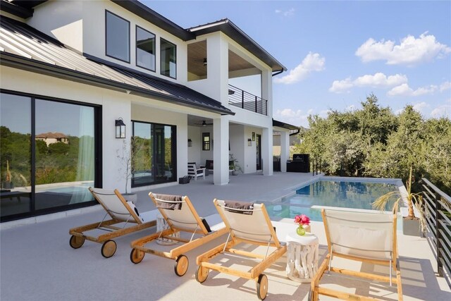 rear view of property with a patio, a balcony, and ceiling fan