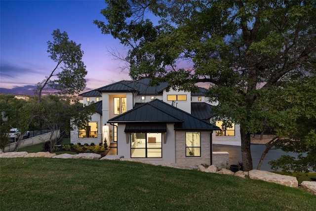 back house at dusk with a yard