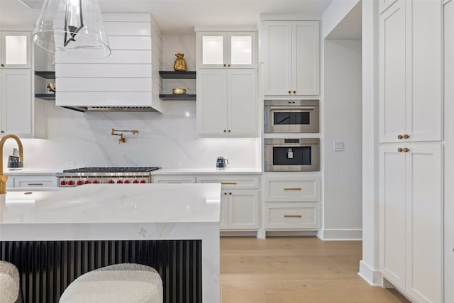 kitchen featuring white cabinetry, light hardwood / wood-style flooring, and decorative light fixtures