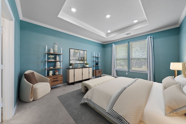 bedroom with crown molding, a textured ceiling, carpet, and a tray ceiling