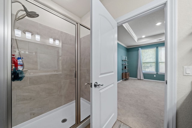 bathroom with ornamental molding and a shower with shower door