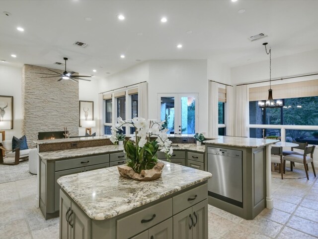 kitchen with dishwasher, a kitchen island, gray cabinetry, and decorative light fixtures