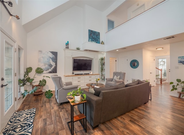 living room featuring dark hardwood / wood-style floors and a towering ceiling