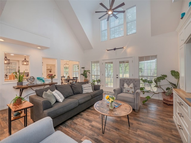 living room with a high ceiling, french doors, dark wood-type flooring, and ceiling fan