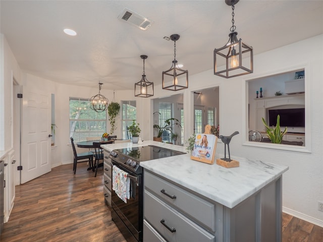 kitchen featuring dark wood-type flooring, black electric range, a center island, and hanging light fixtures