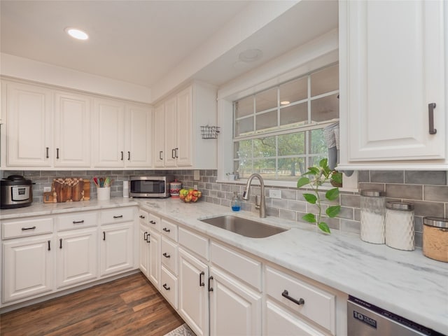 kitchen featuring appliances with stainless steel finishes, dark hardwood / wood-style flooring, backsplash, sink, and white cabinetry