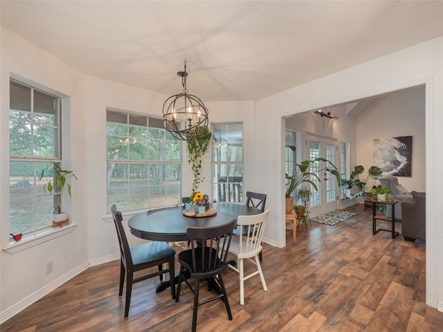 dining space with dark hardwood / wood-style flooring, a healthy amount of sunlight, french doors, and an inviting chandelier