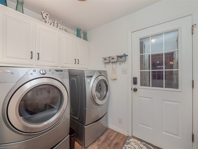 laundry area with cabinets, independent washer and dryer, and dark hardwood / wood-style floors