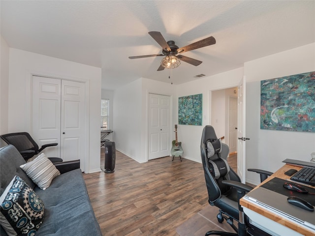 office with ceiling fan, dark wood-type flooring, and a textured ceiling