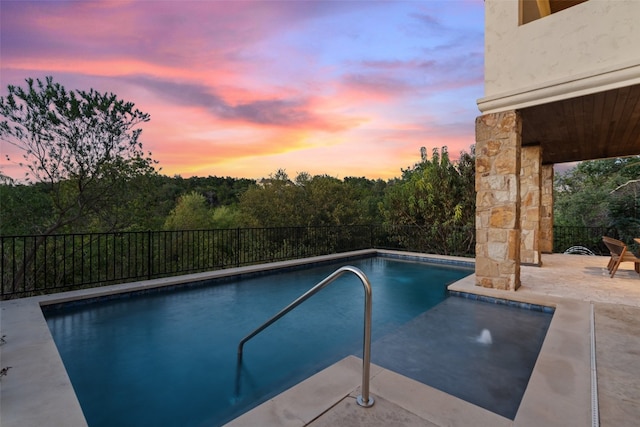 pool at dusk featuring a patio