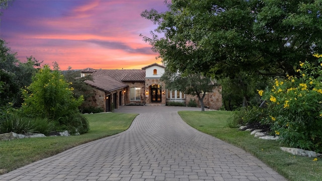 mediterranean / spanish-style house with a lawn