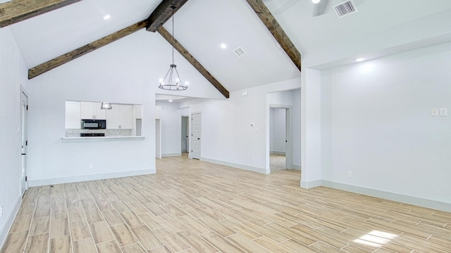 unfurnished living room featuring beamed ceiling, high vaulted ceiling, and ceiling fan with notable chandelier