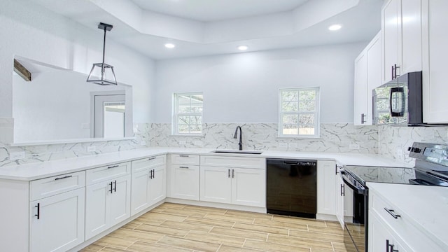 kitchen featuring backsplash, sink, black appliances, decorative light fixtures, and white cabinets