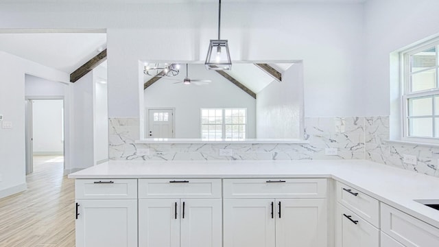 kitchen featuring vaulted ceiling with beams, decorative light fixtures, ceiling fan, and white cabinetry