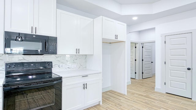 kitchen featuring backsplash, white cabinetry, and black appliances