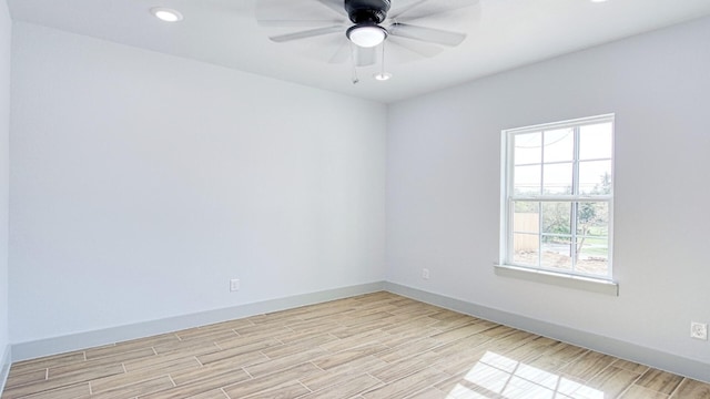 empty room with ceiling fan and light hardwood / wood-style flooring