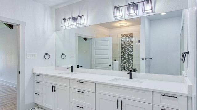 bathroom with hardwood / wood-style floors, vanity, and walk in shower