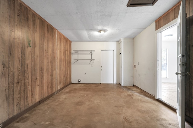 interior space with wood walls and a textured ceiling