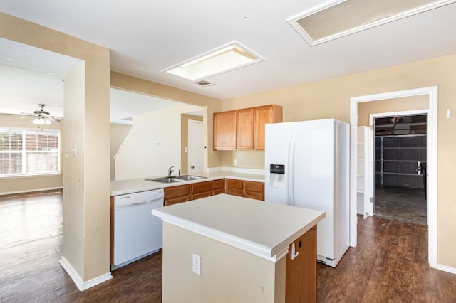 kitchen with sink, dark wood-type flooring, white appliances, ceiling fan, and a center island