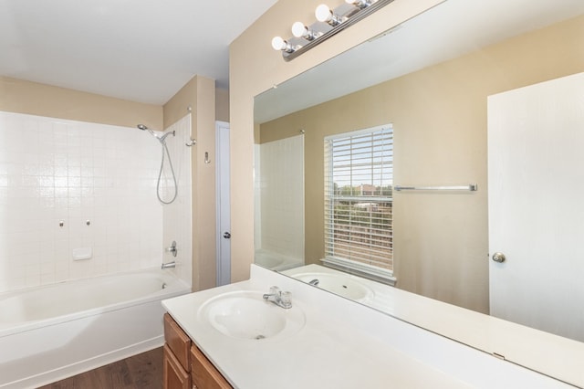 bathroom featuring tiled shower / bath combo, vanity, and hardwood / wood-style floors