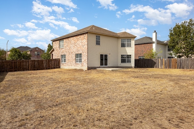 back of property with a yard and a patio area