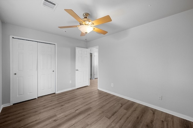 unfurnished bedroom featuring a closet, wood-type flooring, and ceiling fan